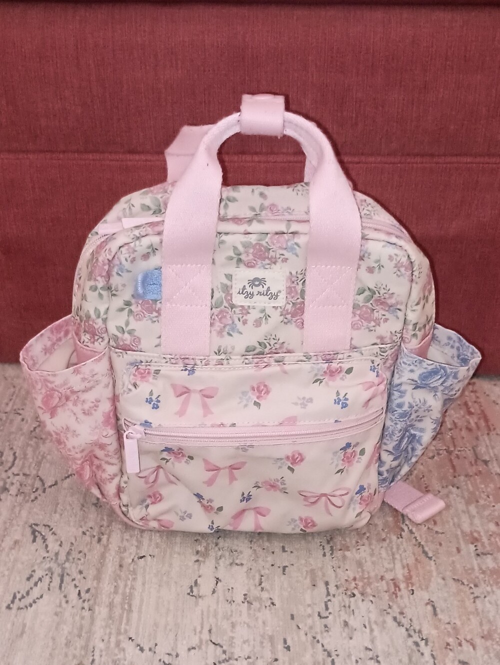 Itzy Ritzy Pastel Floral Bow Print Backpack in Pink and Blue